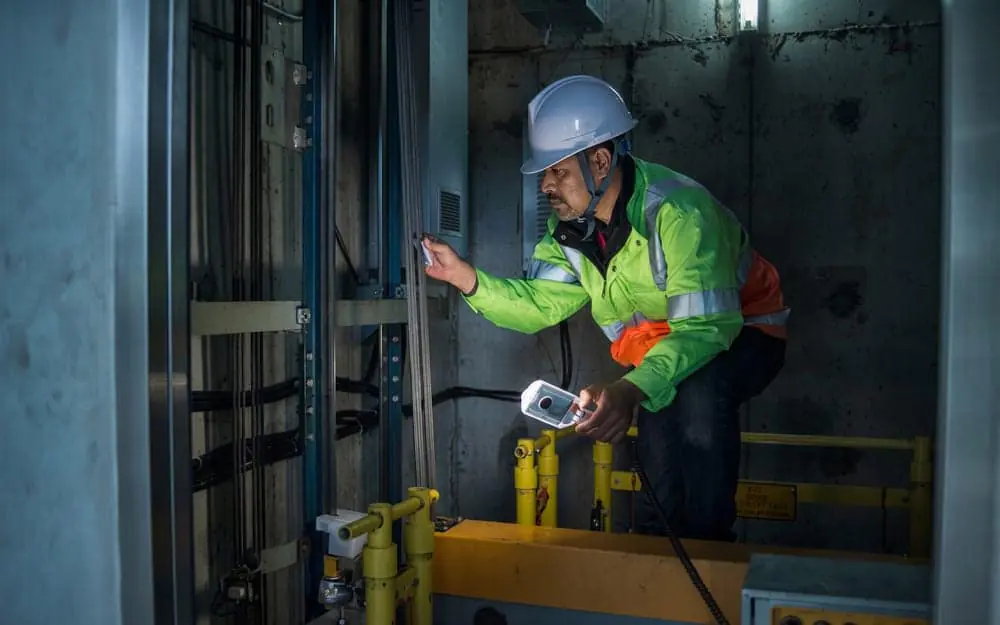 Overhead safety: a technician inspecting an elevator control system